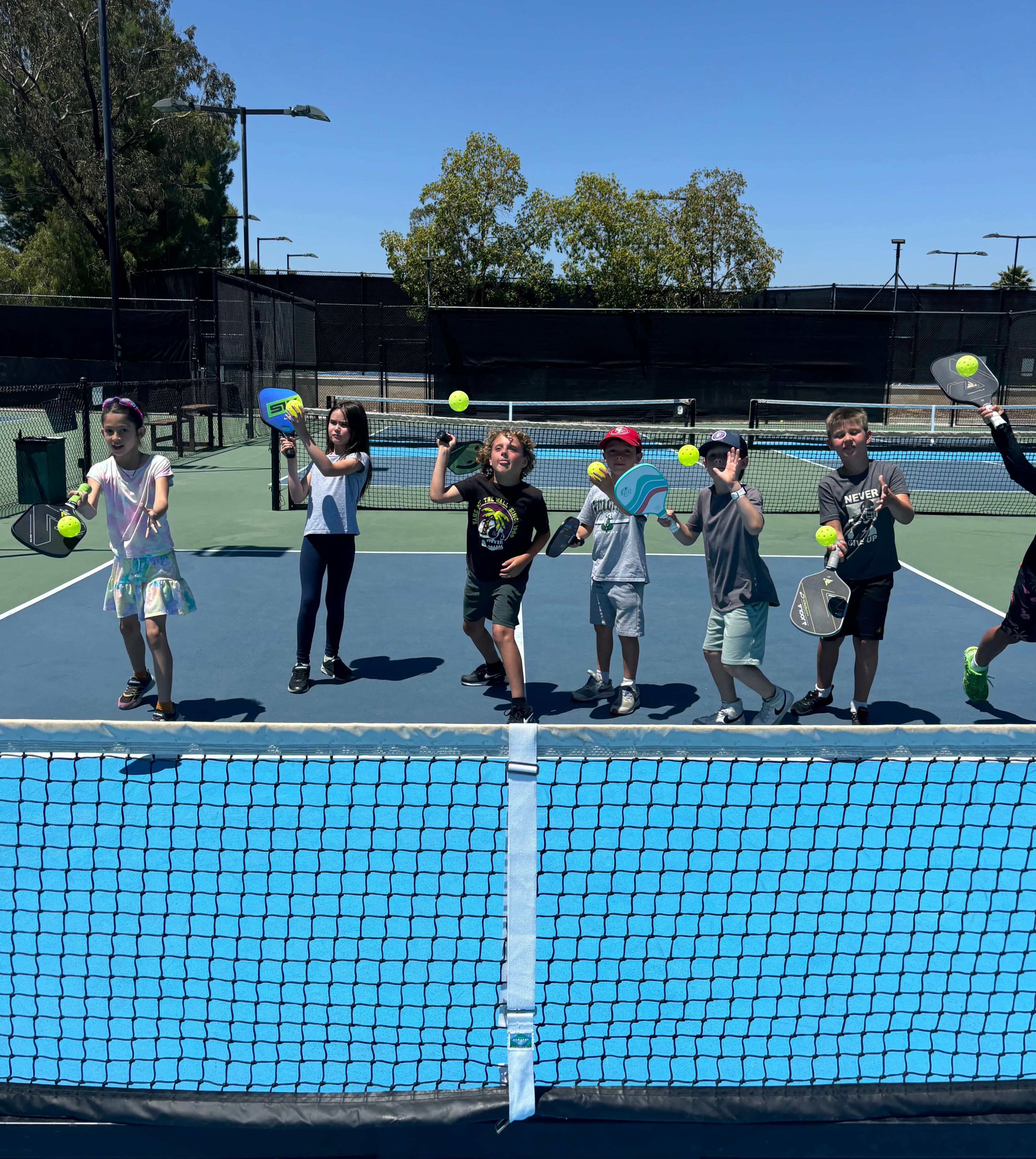 kids hitting balls with pickleball paddles